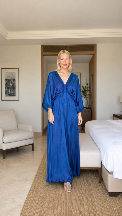 Model wearing a cobalt blue satin-feel kaftan maxi dress with deep V-neck and draped sleeves