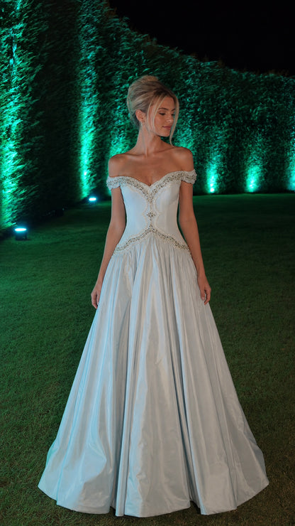Front view of light blue off-shoulder ball gown in garden setting