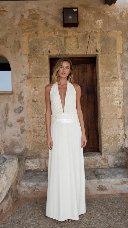 Front view of woman wearing white halter neck maxi dress
