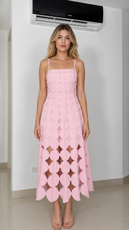 Front view of model wearing pink laser-cut geometric midi dress