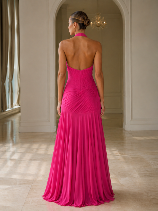 Back view of hot pink halter pleated maxi gown with open back and mermaid hem