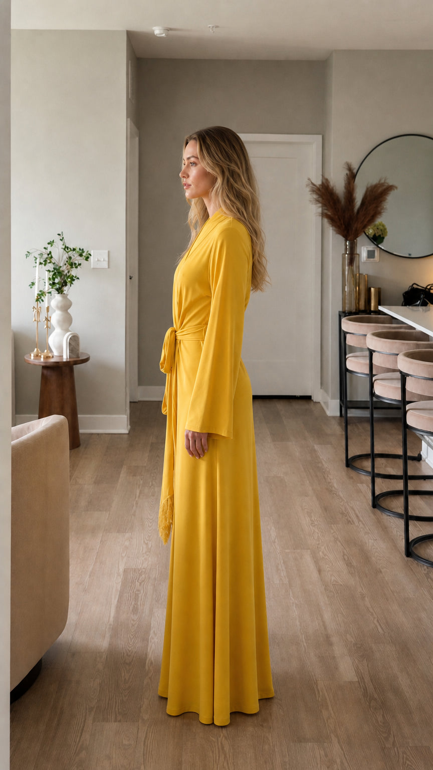 Side profile of model in yellow wrap dress with tie belt