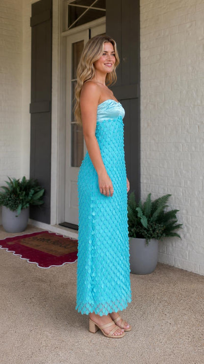 Side profile of model in turquoise strapless maxi dress