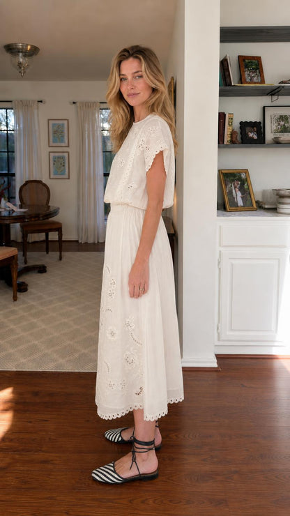 Side view of woman wearing white embroidered midi dress