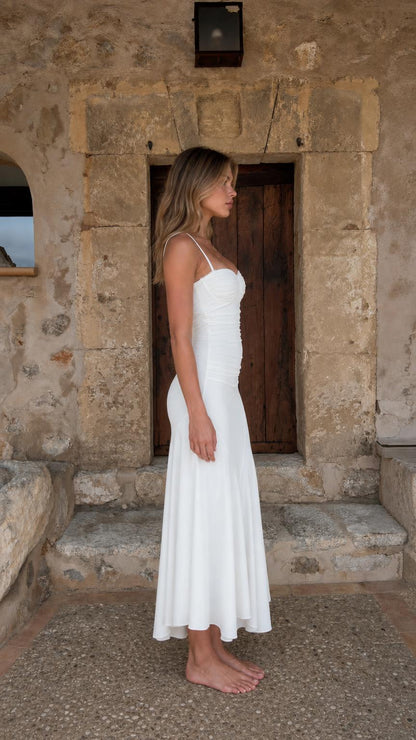 Side profile view of woman in white midi dress