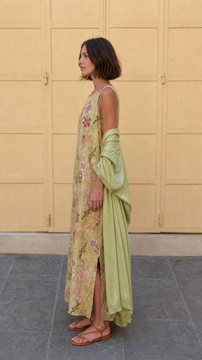 Side profile of model in olive floral maxi dress showing side slit