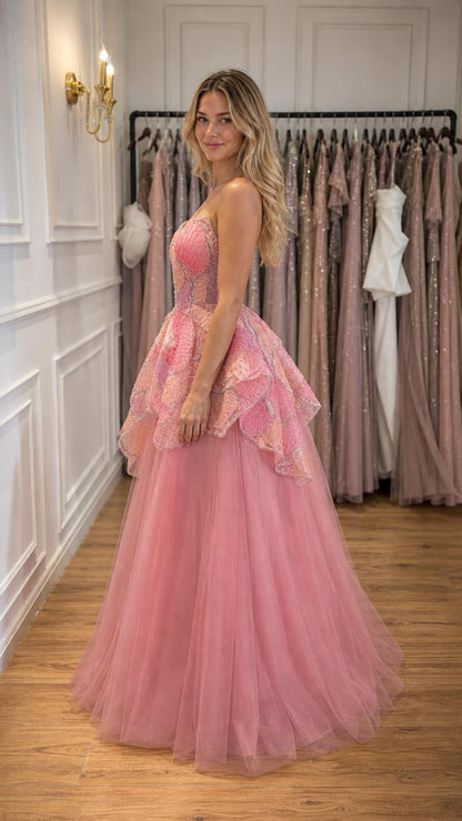 Side profile view of woman wearing pink strapless beaded tulle ball gown