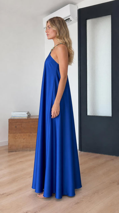 Side profile of model in royal blue satin maxi dress
