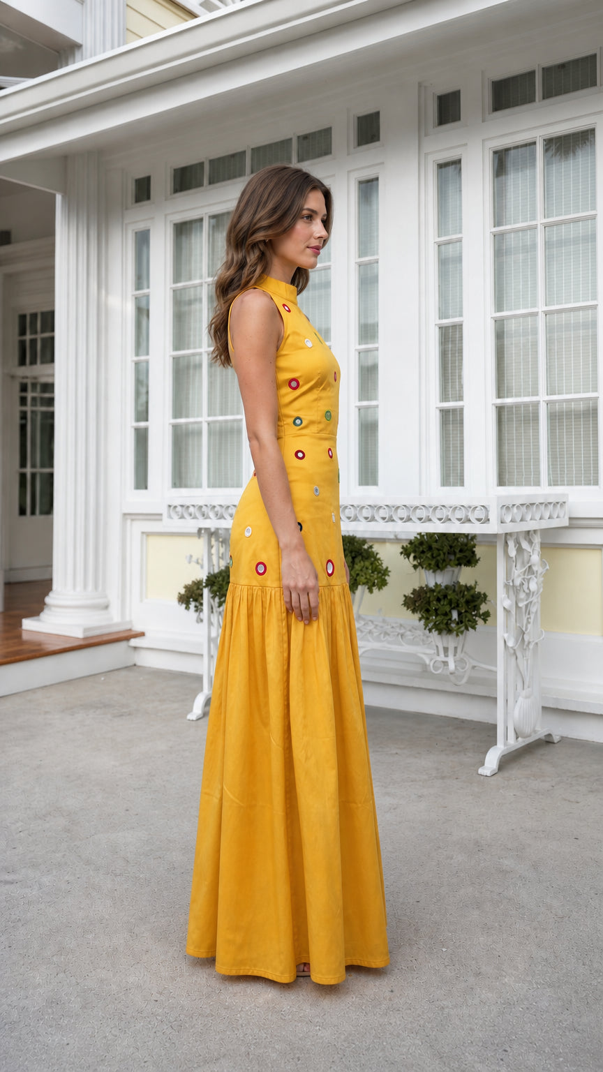 Side view of woman wearing yellow high-neck embellished maxi dress