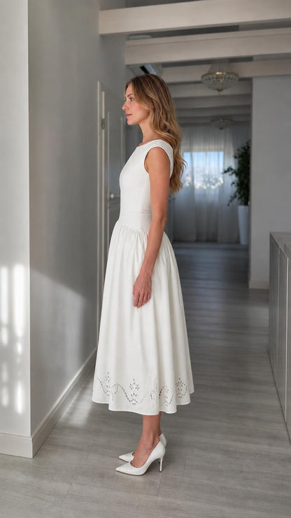 Side profile view of woman wearing white midi dress with heels