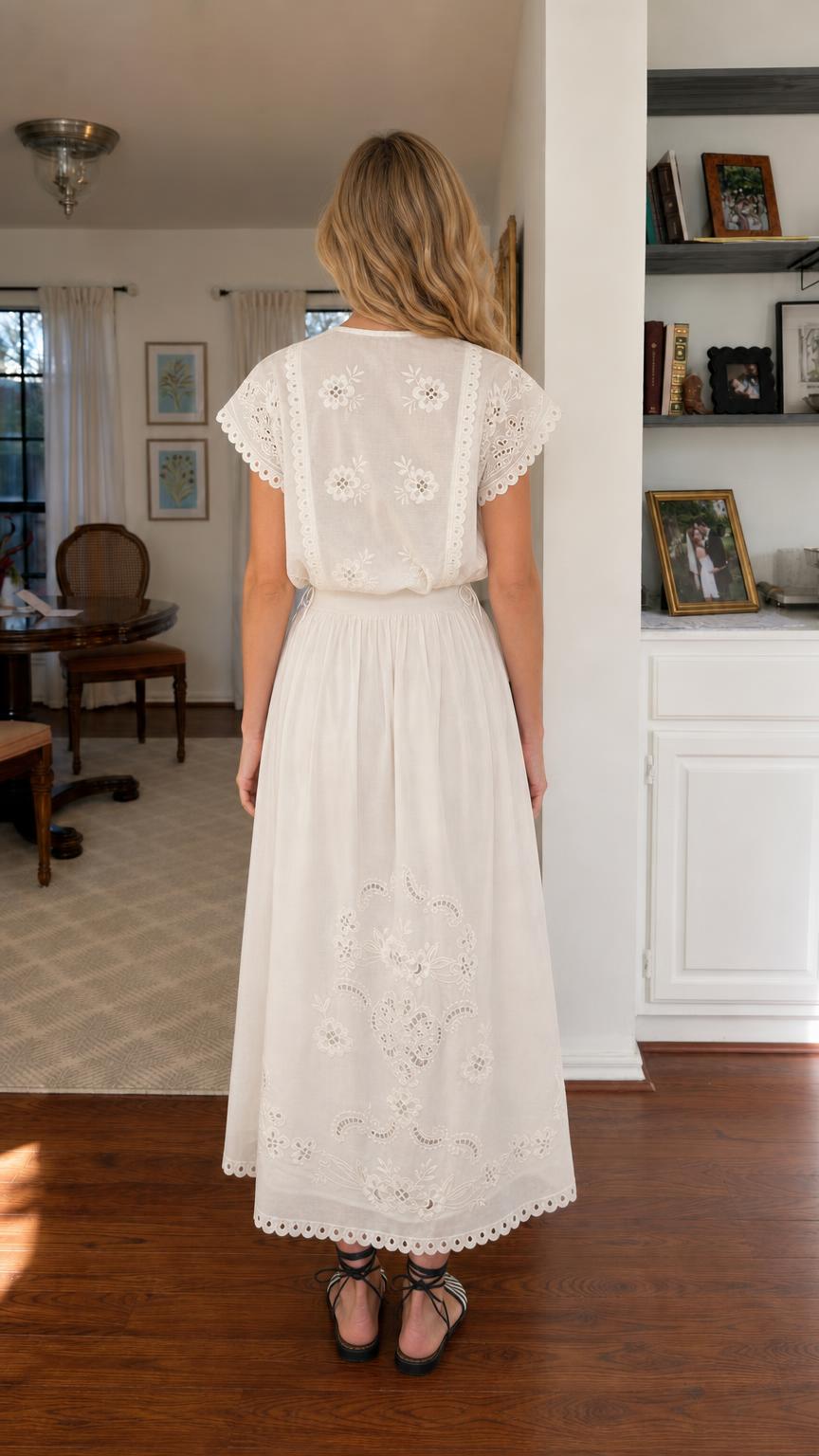 Back view of woman wearing white embroidered midi dress