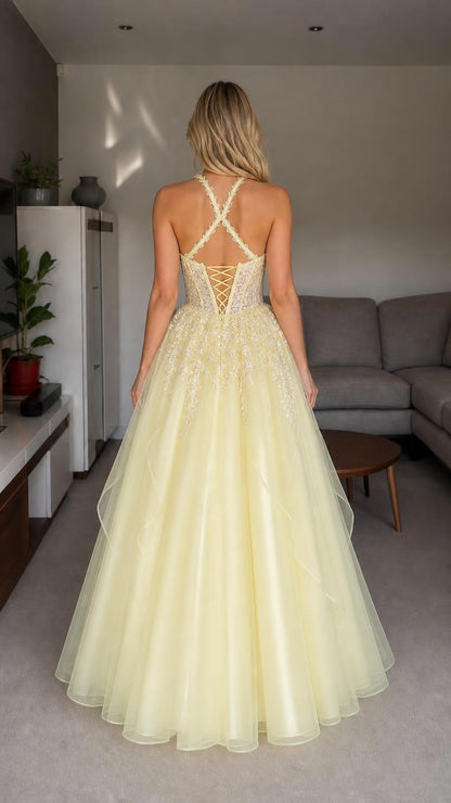 Back view of yellow halter embroidered tulle ball gown showing lace-up details