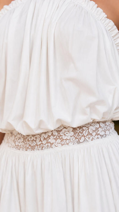 Close-up of gathered bodice and lace waistband on white romper