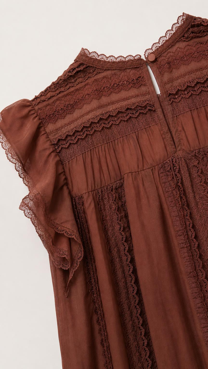 Close-up of brown blouse showing lace panel details and button back closure