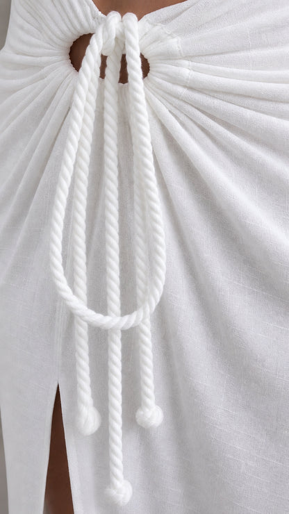 Close-up of decorative rope tie detail on white skirt