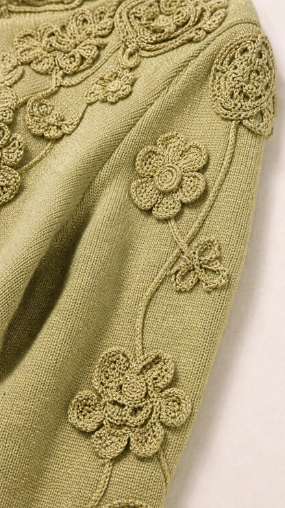 Close-up detail of crochet floral appliques on Sage Green knit sleeve
