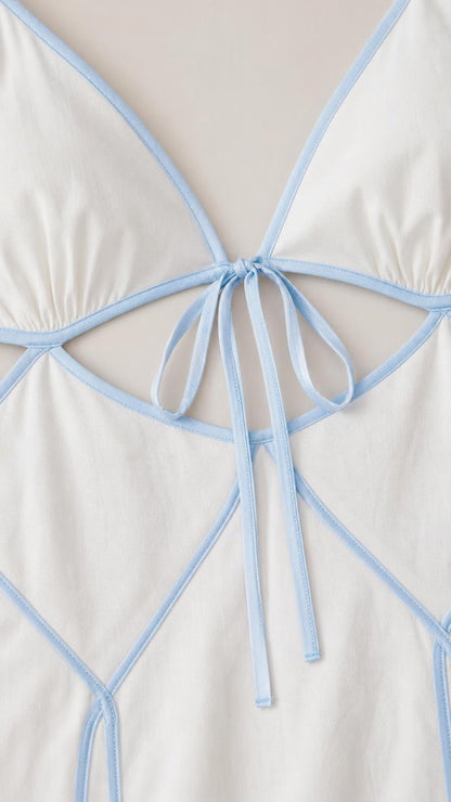 Close-up detail of front tie closure and contrast piping on the dress bodice