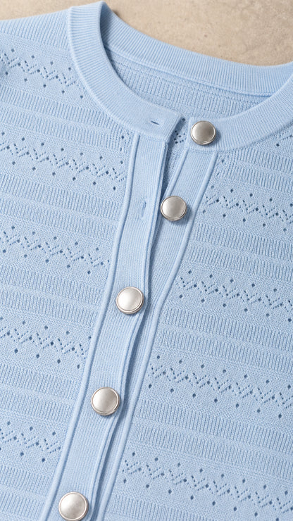 Close-up detail of knit texture and button placket on light blue dress