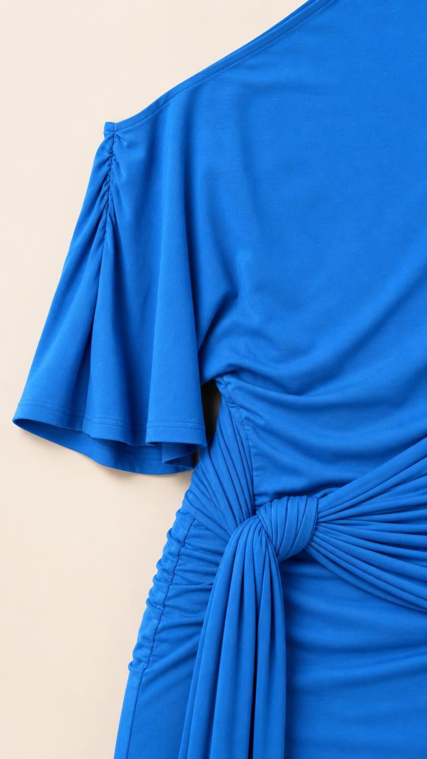 Close-up detail of fabric, ruching, and sleeve on royal blue dress
