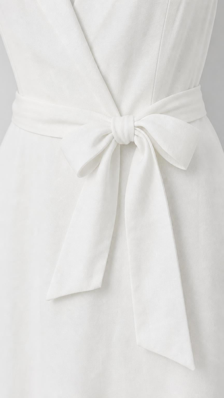 Close-up detail of self-tie bow belt on white dress