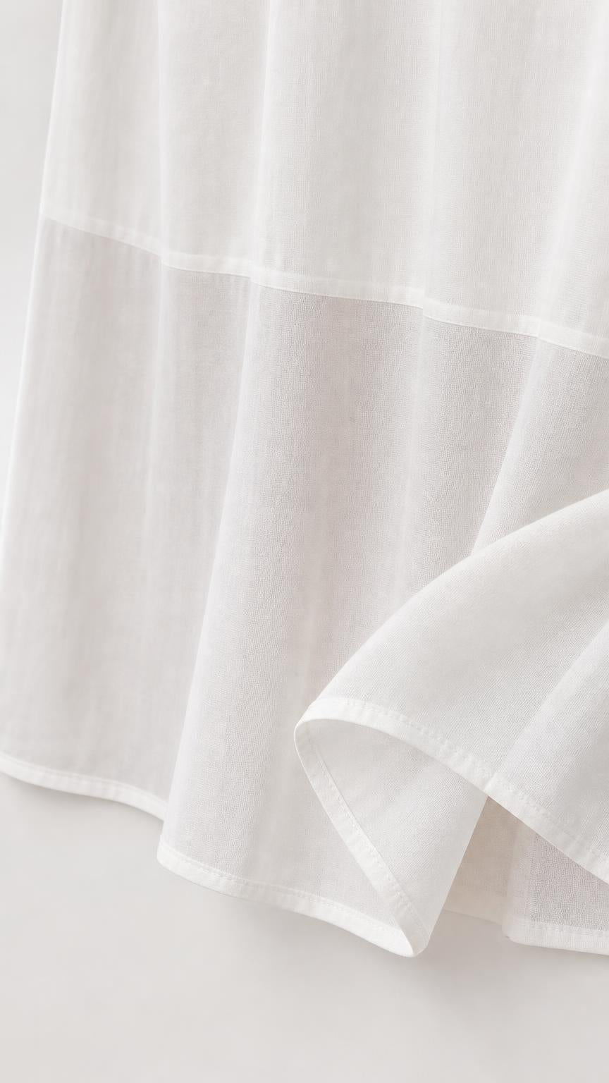 Close-up detail of white dress fabric and hem