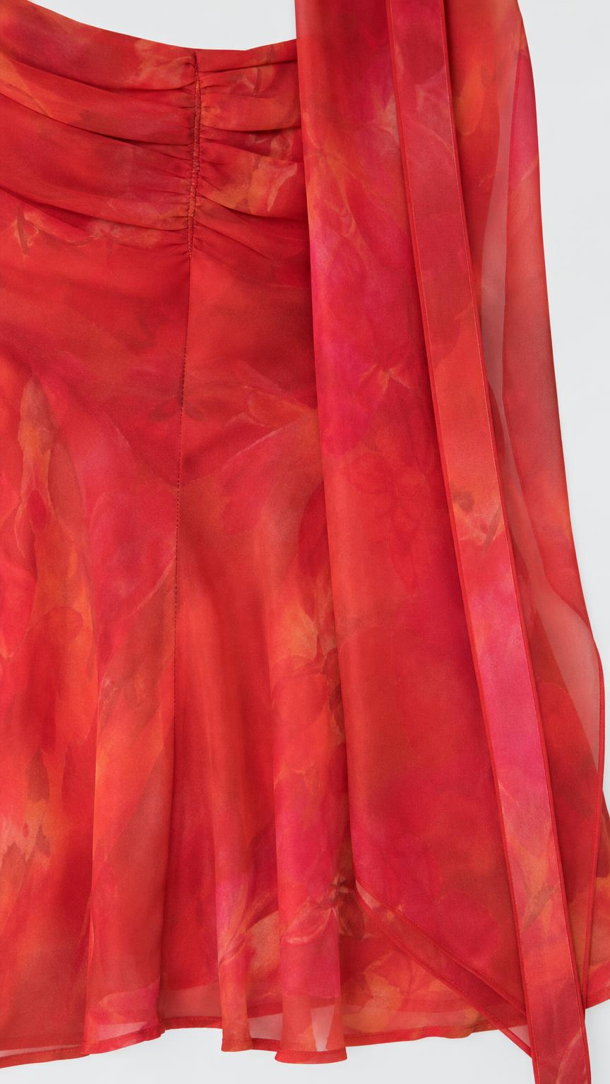 Close up of red floral dress fabric texture and hem