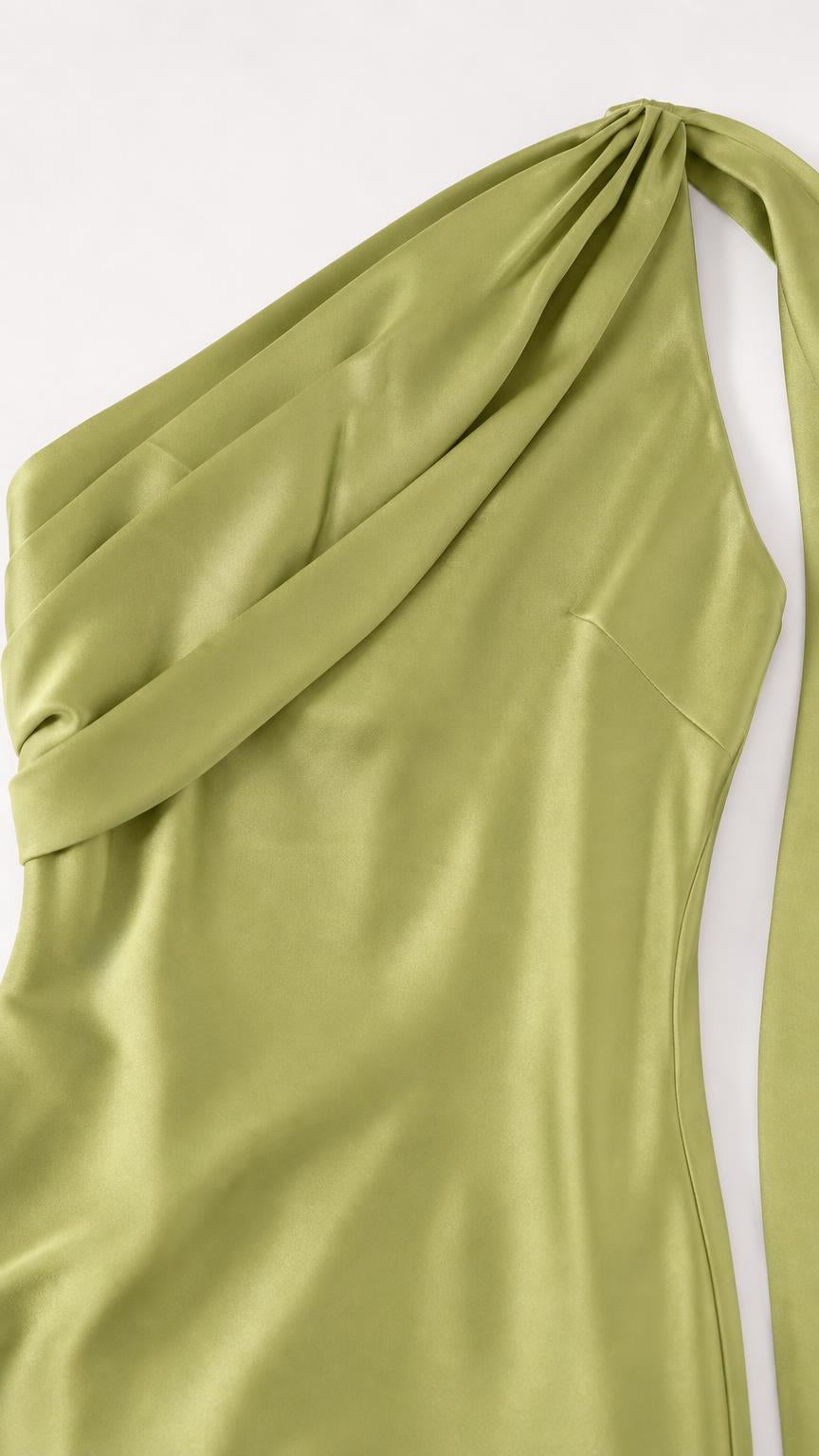 Close-up detail of the one-shoulder draped bodice in green satin