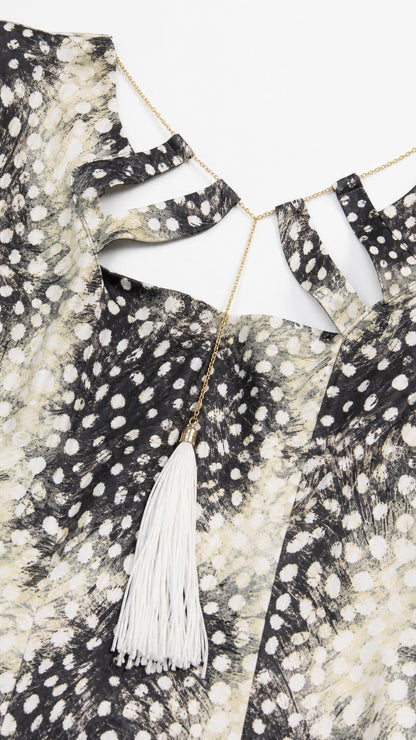 Close-up of the cutout neckline and tassel detail on the dress
