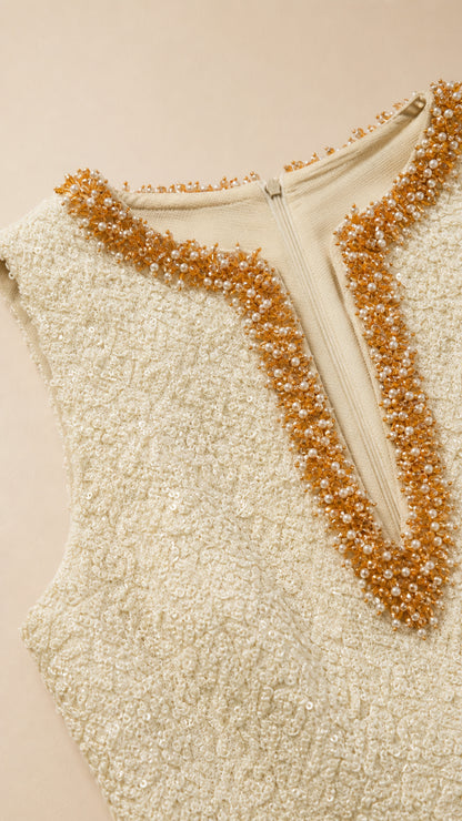 Close-up detail of the gold and bronze beaded V-neckline