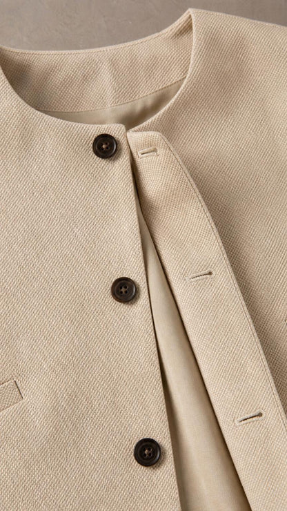 Close-up detail of the beige top neckline and button closure