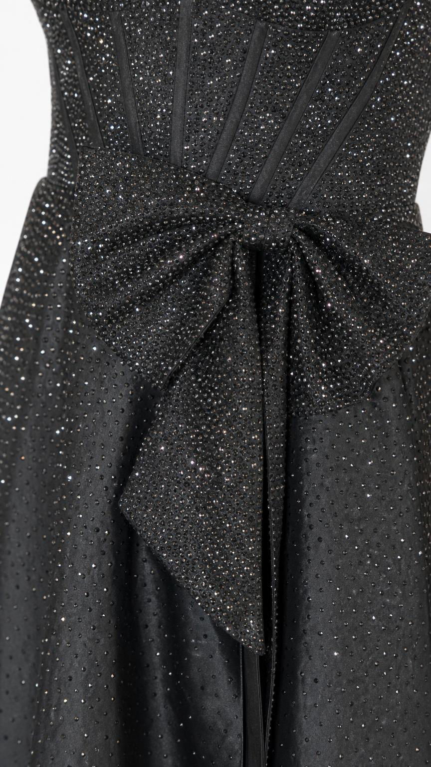 Close-up of waist bow detail on black glitter dress