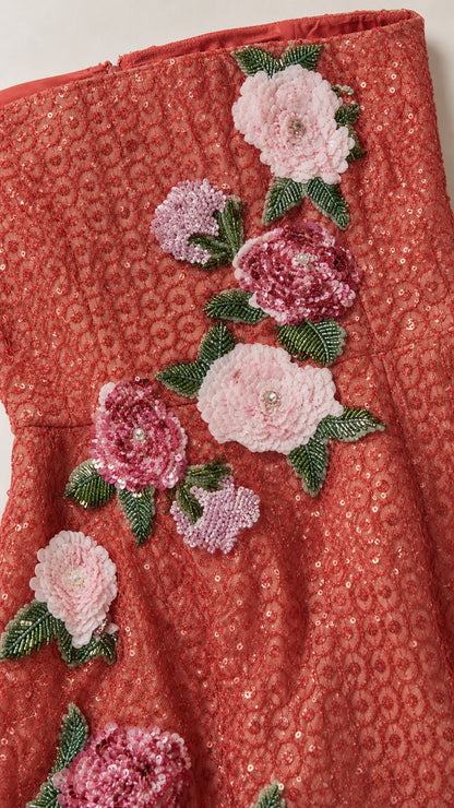 Close-up of red sequin fabric and pink floral appliques