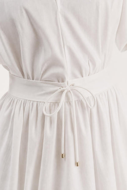 Close-up of drawstring waist detail on white mini dress