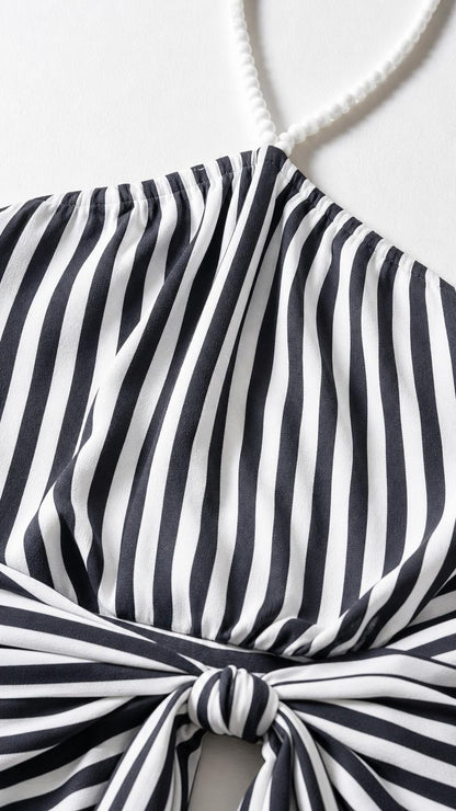 Close-up detail of halter neckline and knotted strap on striped dress