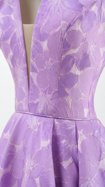Close-up detail of V-neckline and floral brocade fabric