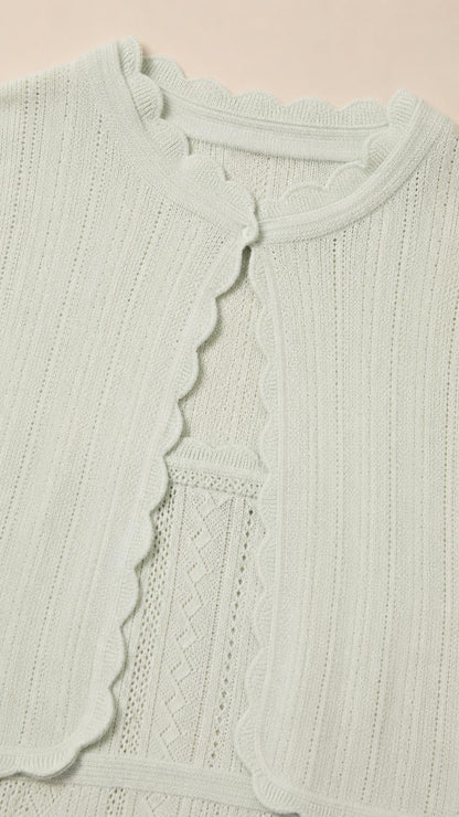 Close-up of mint green cardigan showing scalloped trim and knit texture