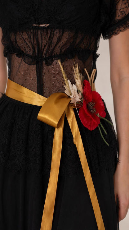 Close-up detail of bodice, lace, and gold floral sash