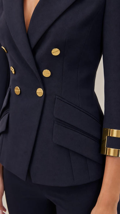 Close-up of navy blazer with gold-tone buttons, angled pocket, and cuff detail