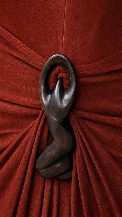 Close-up detail of carved wooden ring accent on dress