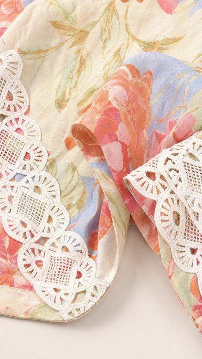 Close-up detail of floral fabric pattern and white crochet lace trim