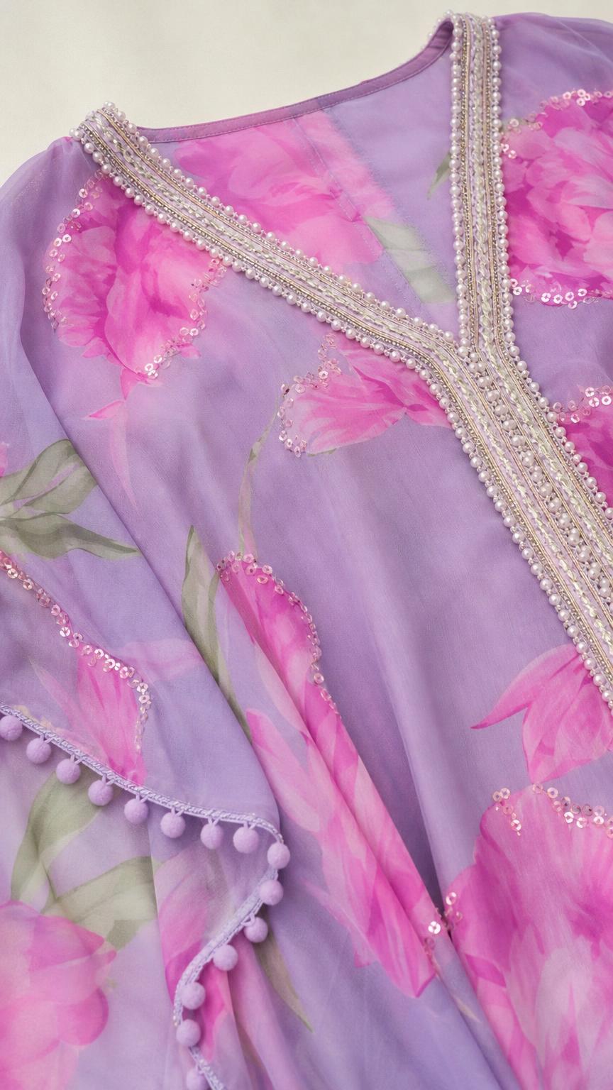Close-up of beaded V-neckline and pom-pom trim on lavender kaftan