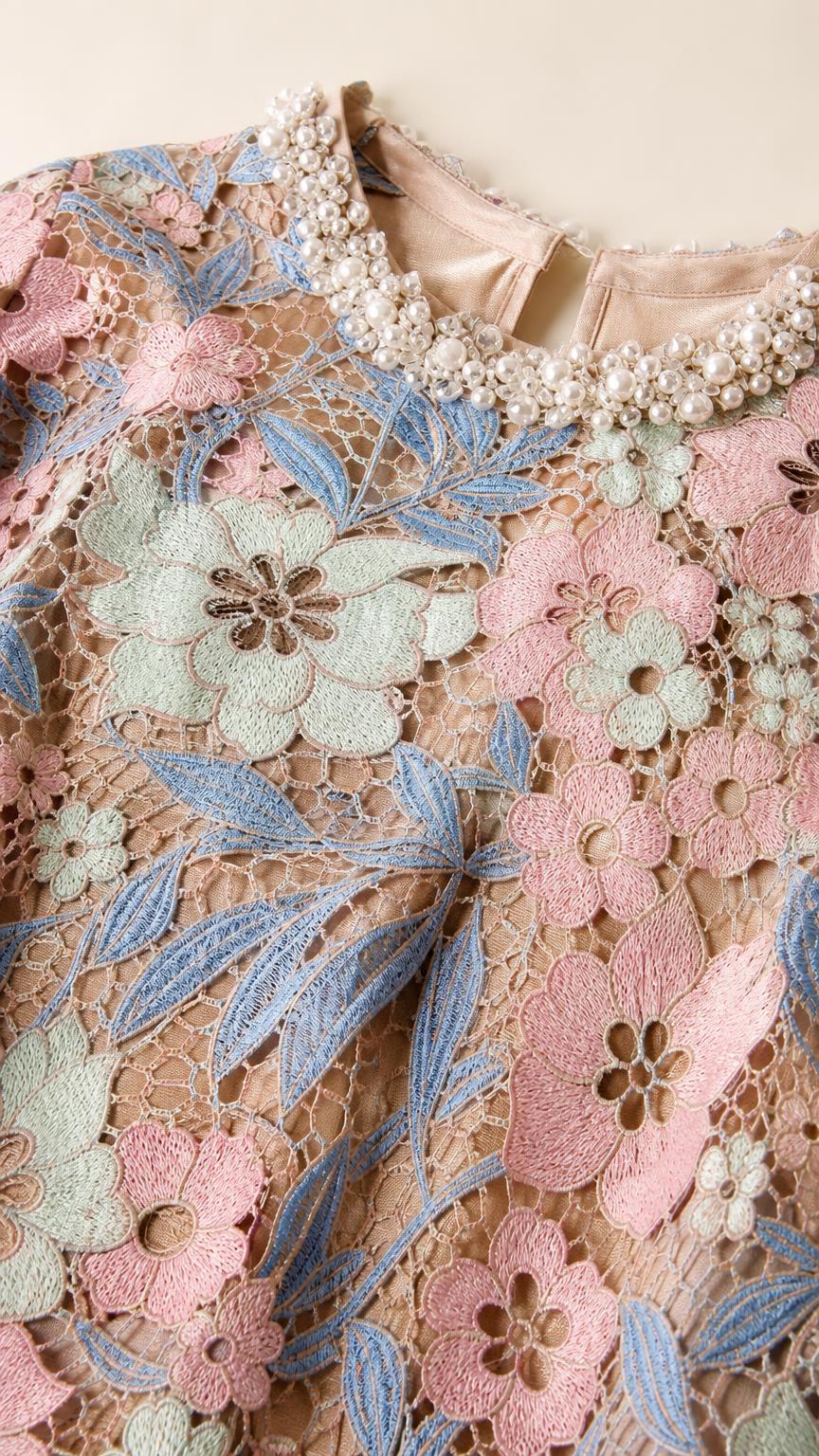 Close-up detail of pearl-embellished neckline and floral lace pattern