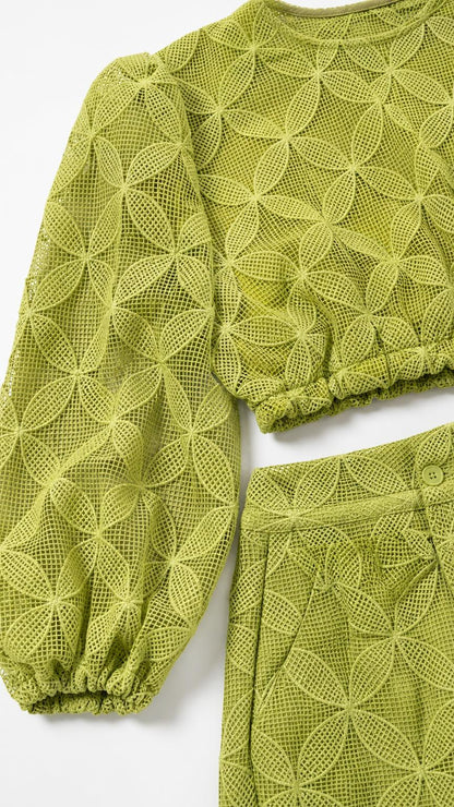Close-up detail of lime green textured mesh fabric on crop top and trousers