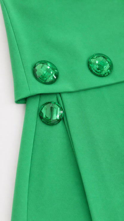 Close-up detail of gemstone buttons on green skirt and top