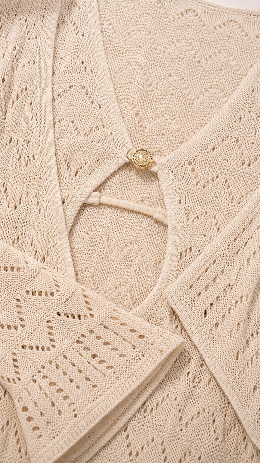 Close-up detail of neckline, ring accent, and knit pattern on beige dress