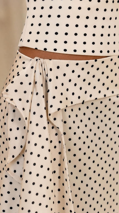 Close-up detail of the side tie and ruffle accent on the polka dot maxi skirt