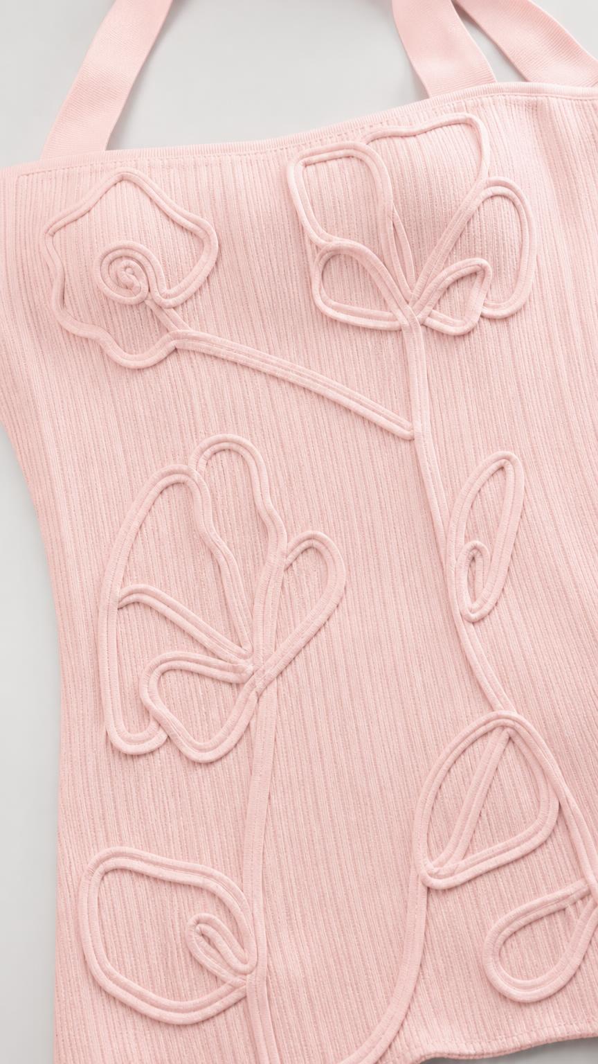 Close-up detail of 3D floral applique texture on pink fabric