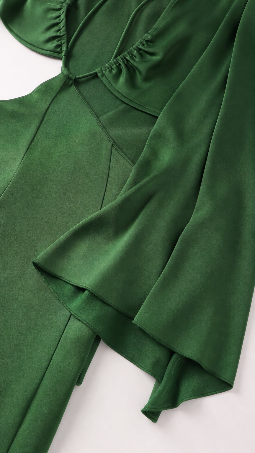 Close-up detail of green satin fabric and sleeve construction