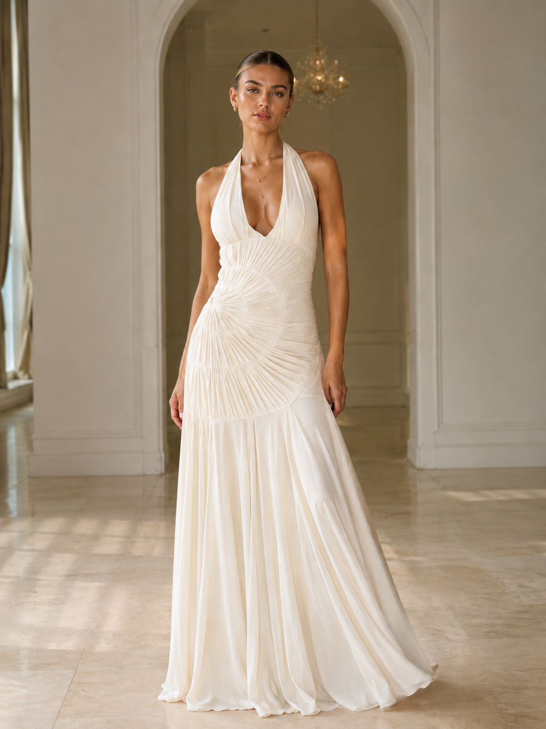 Front view of ivory halter mermaid gown with sculptural pleated detailing