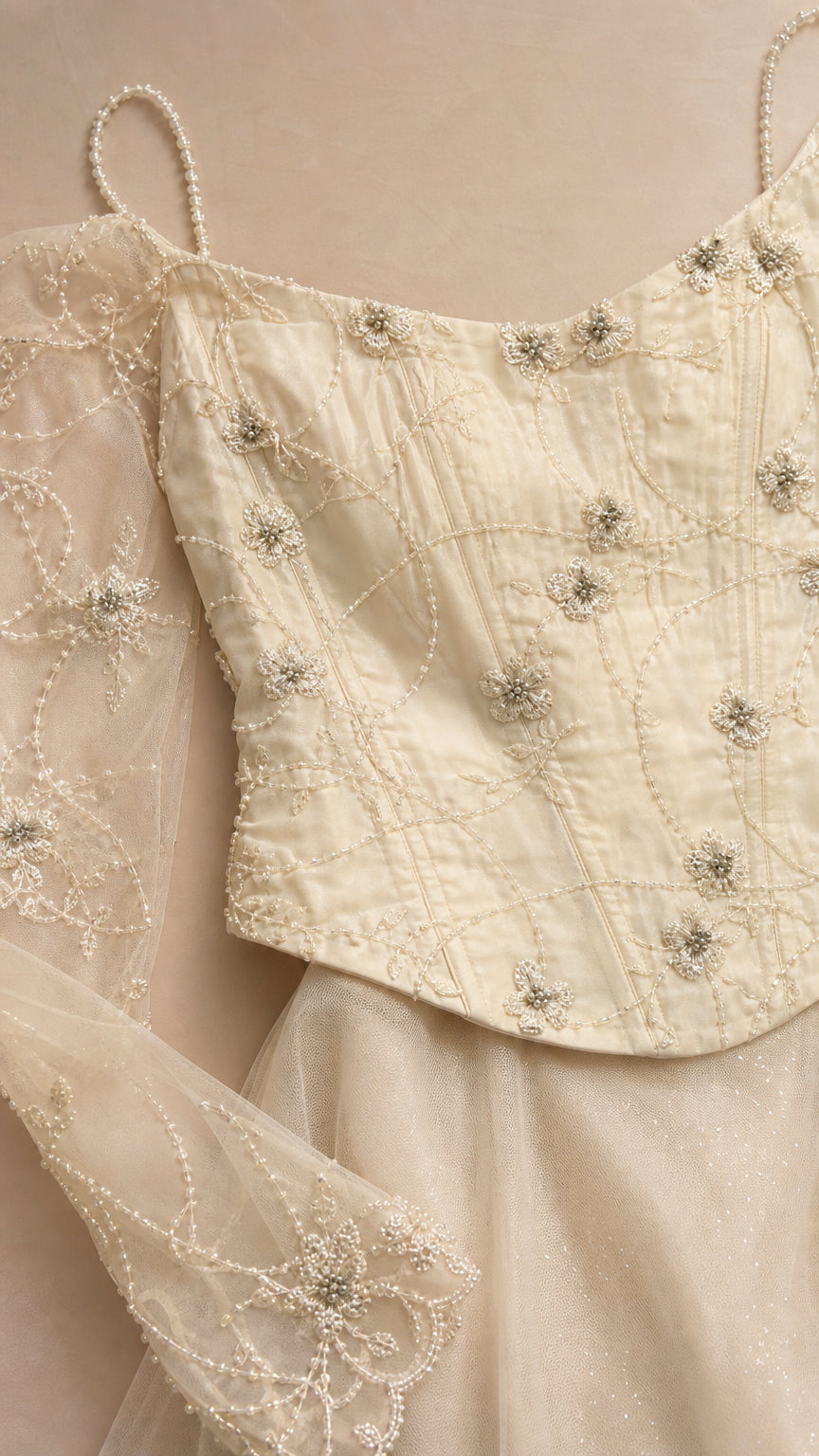 Close-up detail of beaded bodice and sheer sleeves